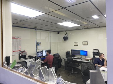 CAM programmers at ACR Machine Co. are visible through a glass window in their newly constructed office space. 