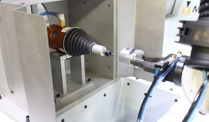 A close-up reveals a robot maneuvering a part around a radially compliant deburring tool. 