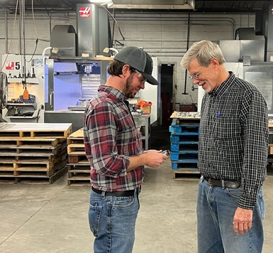 Matt and Larry Sellers discuss a CNC-machined part on the shop floor of Kustom Machining & Manufacturing  in Jackson, Tn. 