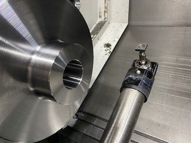 A workholding chuck is visible in the background behind an automatic toolsetting probe in the workzone of a live-tool CNC lathe. 