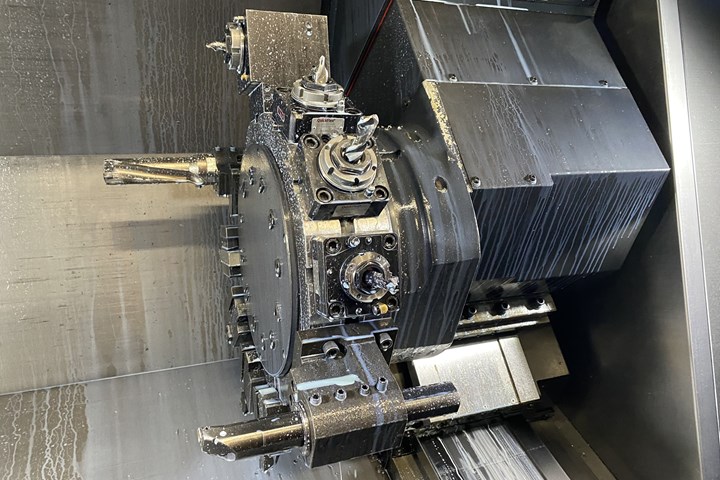 A close-up of a tool turret on a CNC lathe reveals various types of cutting tools. 