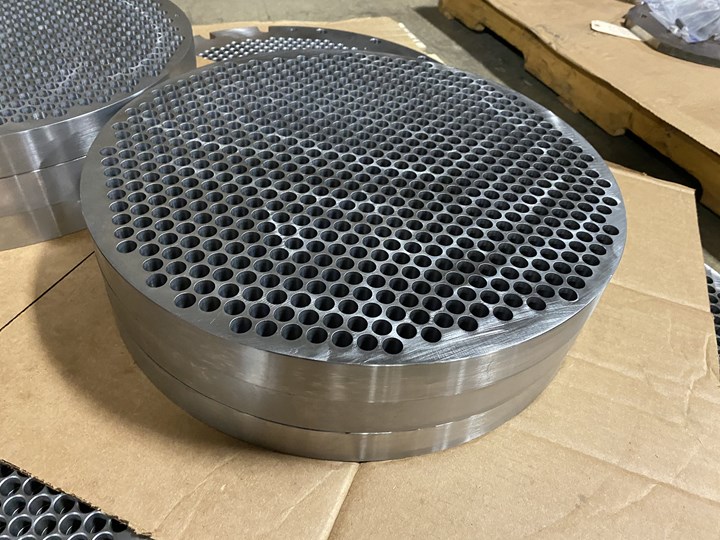 Disc-shaped heat exchangers peppered with nearly 600 holes apiece are arrayed on cardboard boxes at Kustom Machining & Manufacturing in Jackson, TN. 