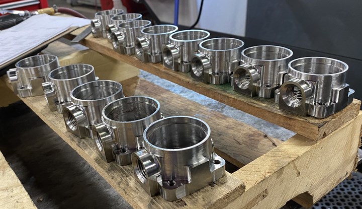 Cylindrical machined parts arrayed on a wooden pallet ready for packaging at Kustom Machining & Manufacturing in Jackson, TN. 