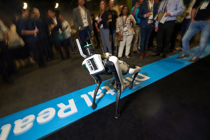 “Spot,” the quadruped robot “dog” from Boston Dynamics, twists toward the camera to show off a Leica BLK ARC laser scanner in front of a group of onlookers at reality-capture technolgoy specialist Hexagon's annual HxGN Live conference in Las Vegas.