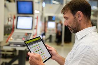 man looking at machine monitoring program on an iPad