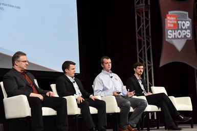 Men sitting in chairs on stage
