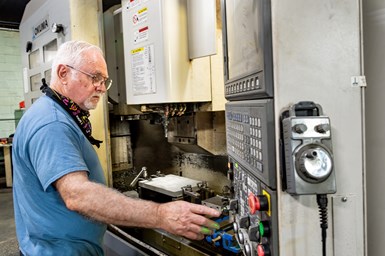 A photo of IMS president David Williams working at a machine control panel