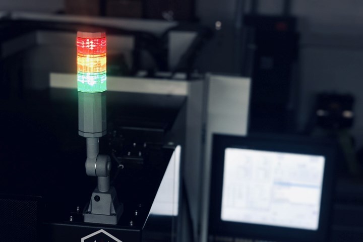 A photo of a machine status light, with a control in the background