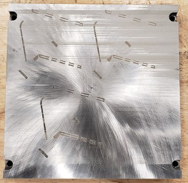A photo of a build plate with residue from a metal AM piece.