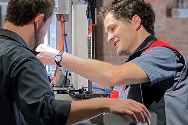 Two people working on a CMM.