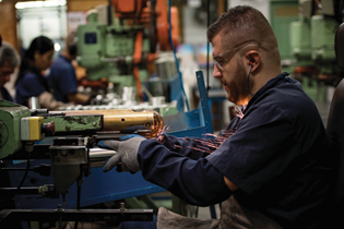 man in machine shop cutting metal