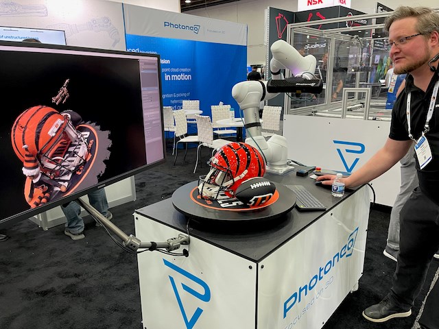 A digital scanner mounted on a cobot arm 3D scanning a Cincinnati Benglas football helmet