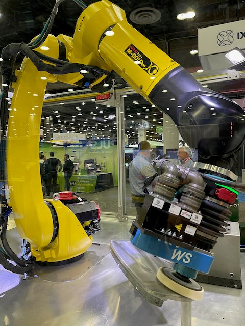 a yellow robot outfitted with an electric end effector designed for robotic grinding, sanding and polishing. 