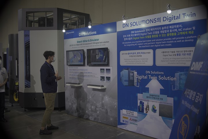 Man standing in front of exhibit about digital twins in manufacturing