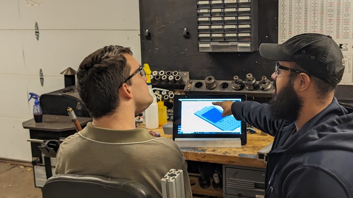 La imagen muestra a Devin Hamilton (izquierda) y al asistente de ingeniería Alex Peña trabajando en el sitio para servicios de programación por contrato. Hamilton utiliza una tableta para conectarse de forma remota a su estación de trabajo CAD en la oficina