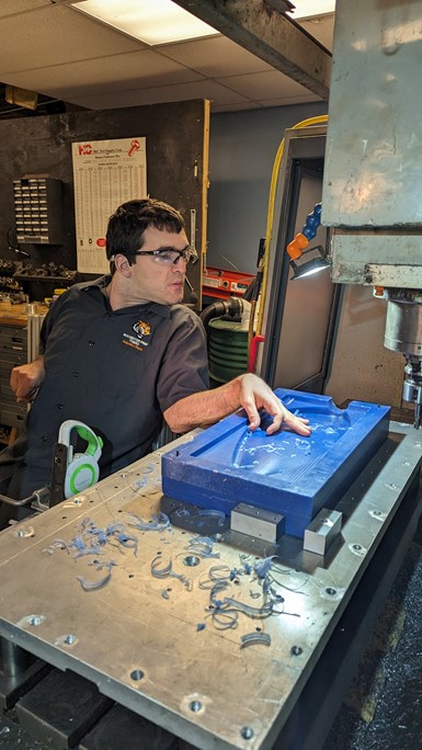 Although Devin Hamilton has lived with cerebral palsy since childhood, his persistent focus on enabling technologies has been a key to success as an engineer and manufacturing entrepreneur. Here, he is checking the smoothness of the surface on a mold contour.