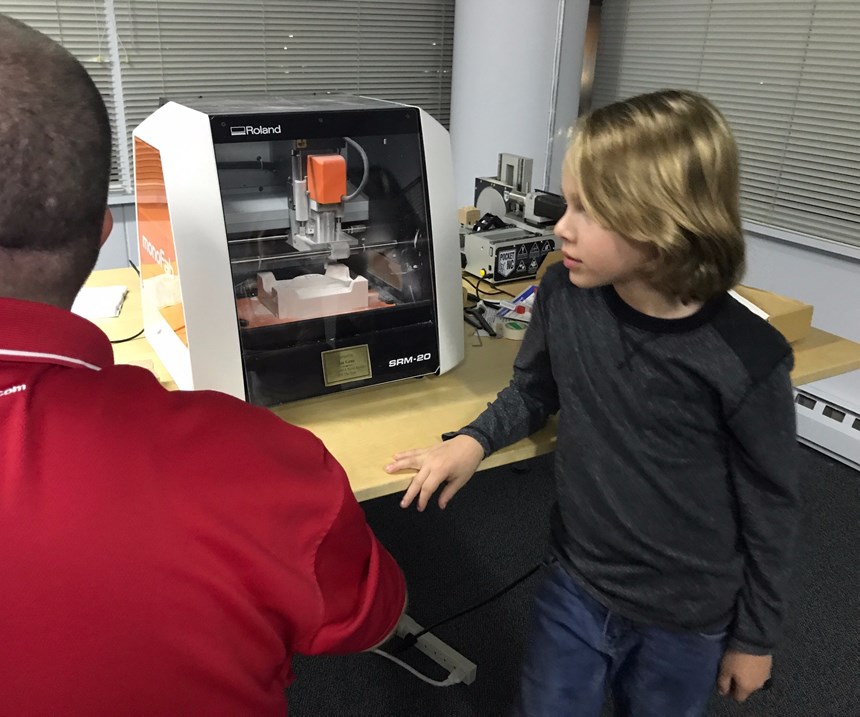 Seven-year-old Leo Fisher learns about CNC milling at American Mold Builders Association meeting.