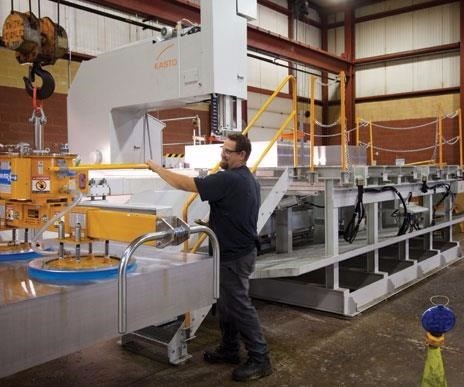 worker processes the next generation of aluminum mold material on a metal-cutting saw