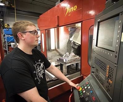 Machinist operates FPT Dino high-speed, five-axis, bridge-style CNC mill