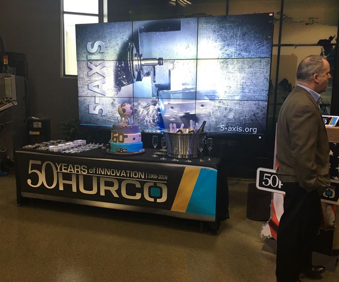 Hurco 50th display with a banner, video and cake