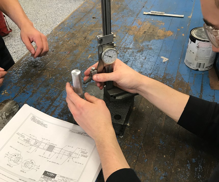 Using a height gauge to measure a workpiece in advanced manufacturing.