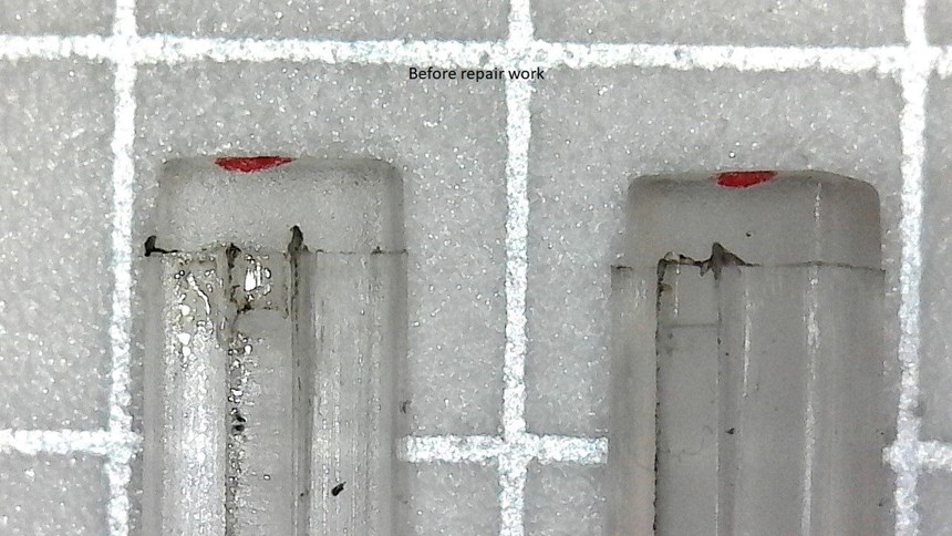 Damaged legs of a micro-sized plastic part for an automobile dashboard light.