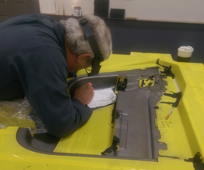 A technician at Custom Etch manually applying a pattern for texturing a mold.