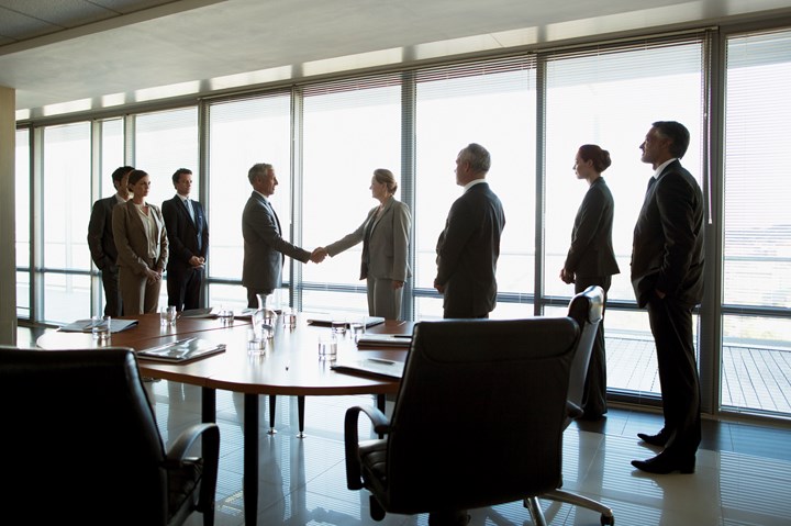 Businessmen and businesswomen shaking hands.