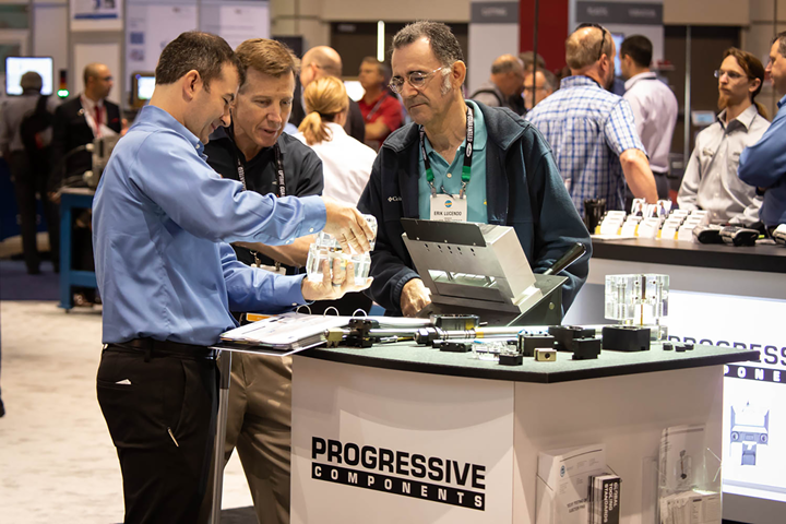 men at progressive components booth at tradeshow