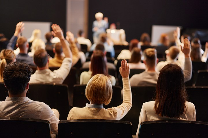 People raising their hands during an event seminar