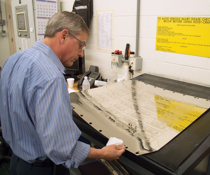 man looking at printing plate