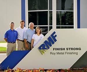 members of the Roy family in front of company sign