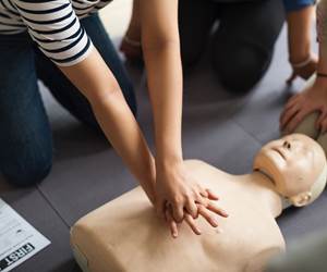 person performing cpr on a practice dummy.