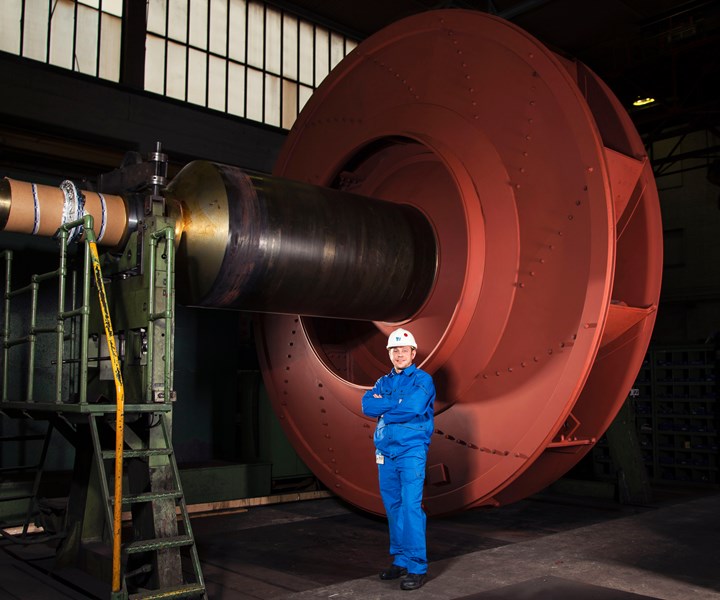 man standing next to large fan