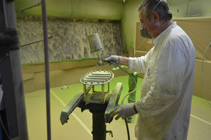 man spraying liquid coatings