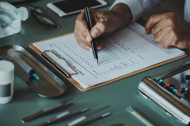 A stock photo of a man making notes on a checklist.