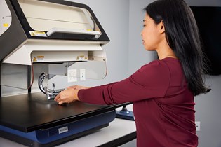 woman putting a coated part on an XRF machine