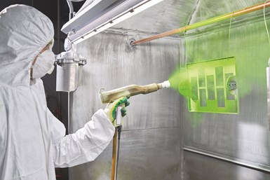 A person powder coating with a green powder.