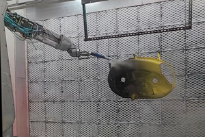 Robot spraying a part.