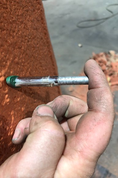 Man's hand is holding measurement tool showing finish coating of 9mm.