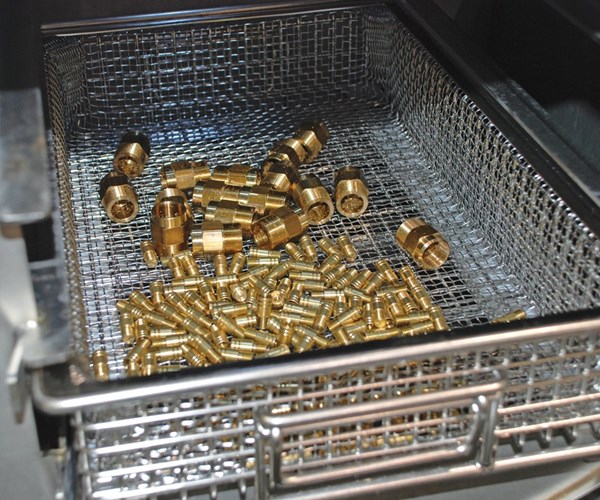 cleaned brass parts in a basket