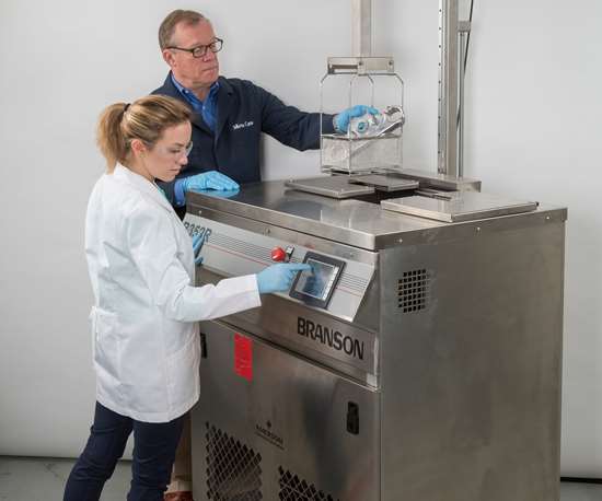 two people operating a vapor degreasing machine