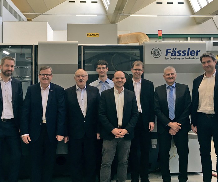 key employees at Gleason and Faessler standing in front of a Faessler machine