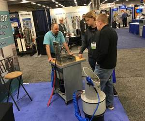 show attendees learning about a cleaning machine in an exhibitor booth