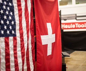 美国和瑞士国旗与赫尔工具的标志在背景