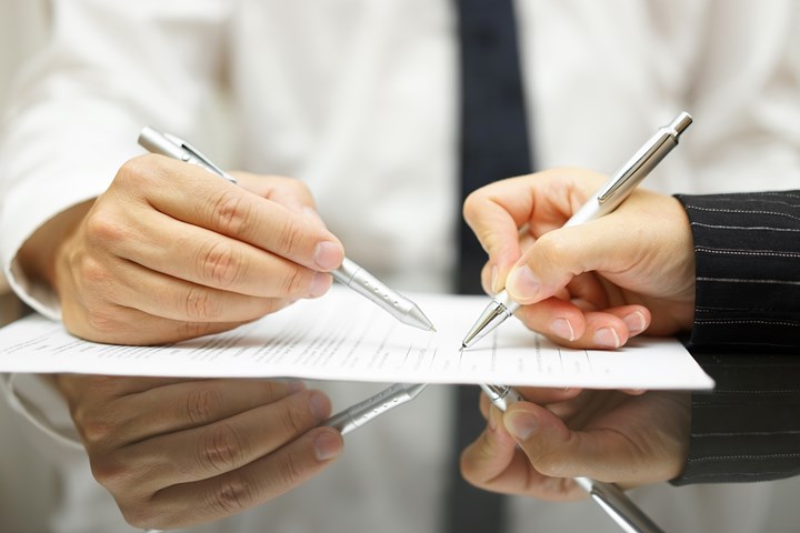 two people signing an agreement