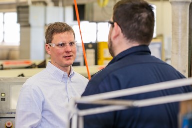 Doug Coster talking to operator on the shop floor 