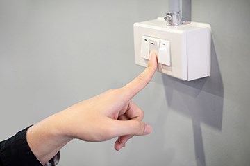 finger turning a light switch off