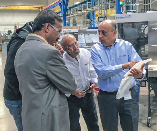 Suhas Kulkarni (derecha) instruye a los participantes durante un taller de DOE en la planta del moldeador personalizado Comar en California.