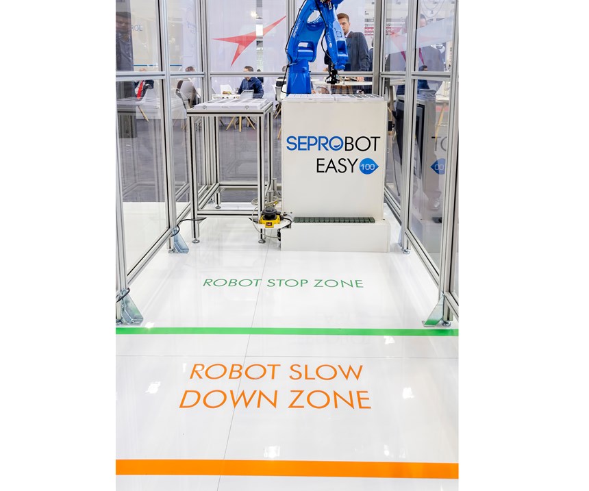 The SeproBot concept uses the speed and versatility of a conventional six-axis robot (or a Cartesian model), surrounded by physical guarding but giving operators safe access through openings protected by sensors, light curtains or other safety devices. 